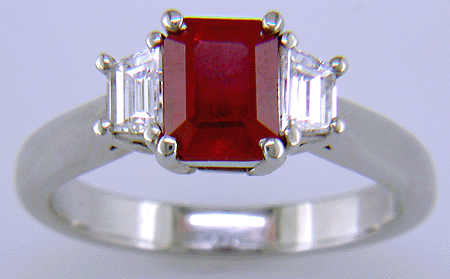 A fiery red ruby set with two trapezoid-cut diamonds in a hand-crafted platinum ring. (J6405)