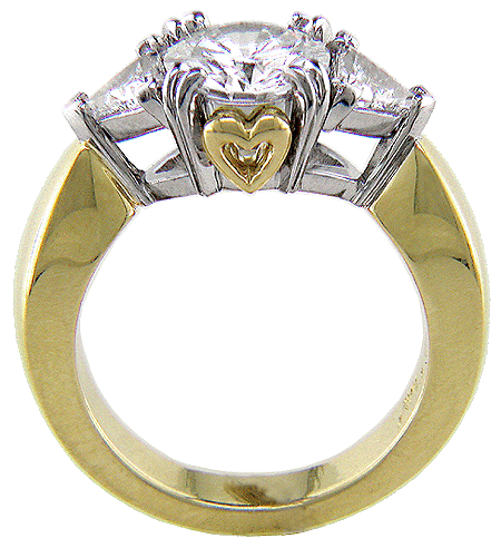 Three-stone diamond engagement ring crafted in 18kt gold and platinum with hidden hearts.
