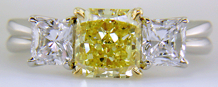 Fancy Intense Yellow diamond set with two radiant-cut diamonds in a custom platinum ring.