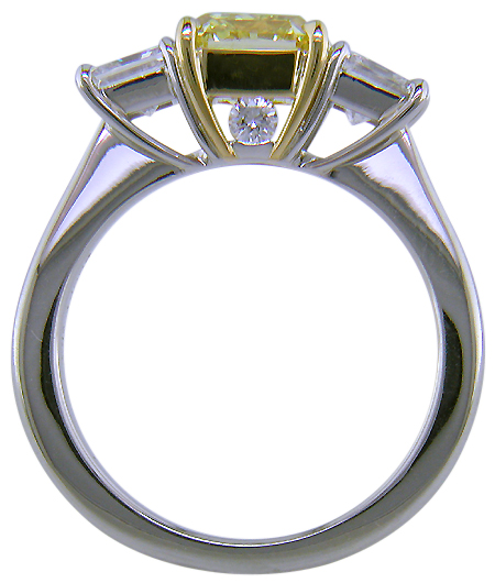 Fancy Intense Yellow diamond set with two radiant-cut diamonds in a custom platinum ring.