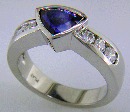 Channel set diamonds in trillium sapphire platinum ring.