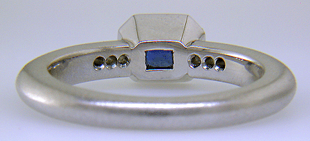 Inside view of emerald-cut sapphire set with round brilliant-cut diamonds in a custom platinum ring.