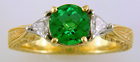 Head-on view of 18kt gold ring with tsavorite garnet and diamonds set in platinum.