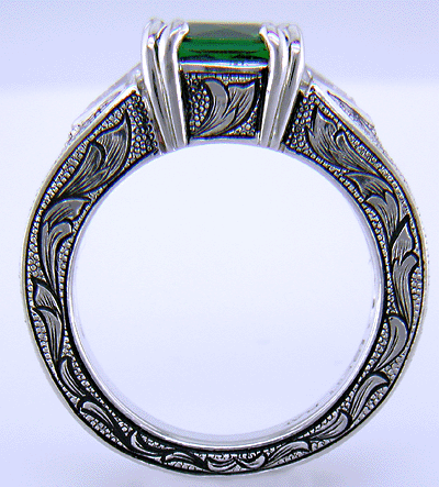 A cushion-cut Tsavorite garnet set in a beautifully hand crafted and engraved platinum ring.