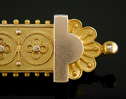 Close up of Victorian Gothic Revival gold brooch.
