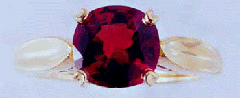Face-on view of red spinel ring with two diamonds.