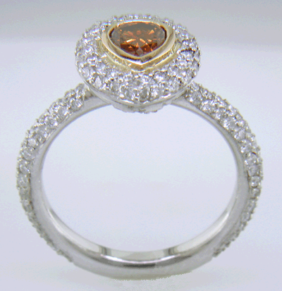 Side view of orange diamond set with pave diamonds in a platinum ring.