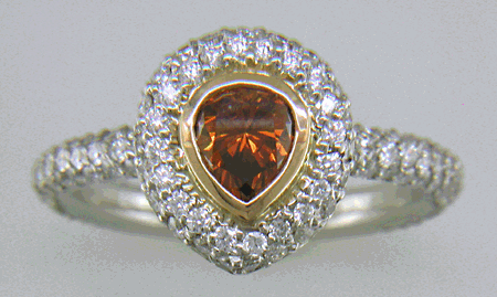 Orange diamond set with pave diamonds in a platinum ring.