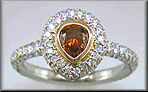 Orange diamond set with pave diamonds in a platinum ring.