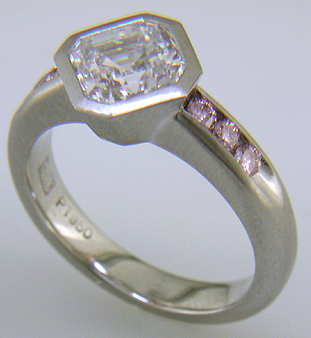 An Asscher diamond set with Fancy Intense pink diamonds in a custom platinum engagement ring.