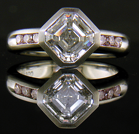 An Asscher diamond set with Fancy Intense pink diamonds in a custom platinum engagement ring.