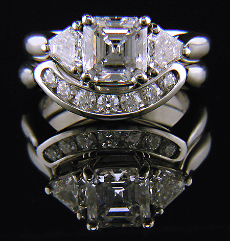 An Asscher-cut diamond set with two calf-head diamonds in a handcrafted platinum ring.