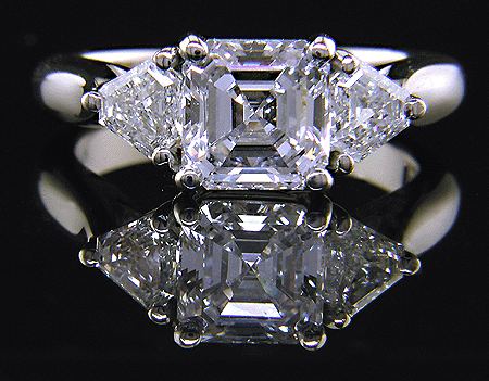 An Asscher-cut diamond set with two calf-head diamonds in a handcrafted platinum ring.