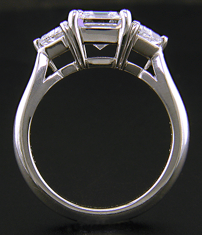 Side view of Asscher-cut diamond set with two calf-head diamonds in a handcrafted platinum ring.