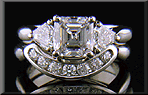 An Asscher-cut diamond set with two calf-head diamonds in a hand-crafted platinum ring.