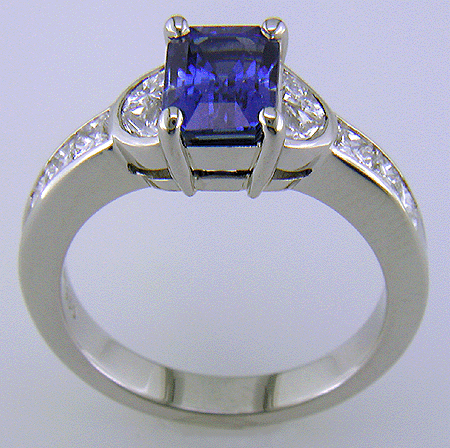 Side view of emerald-cut sapphire and diamond ring in platinum.