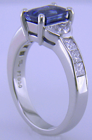 Emerald-cut sapphire and diamond ring in platinum.
