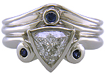 A trilliant diamond ring with three small sapphires.
