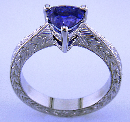 Side view of platinum hand-engraved ring with trillium color change sapphire.