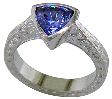 Concaved-faceted trillium Sapphire set in a handcrafted, hand-engraved platinum ring. (J8707)
