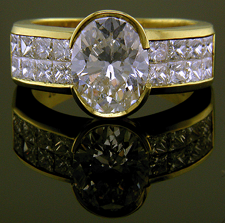 18kt gold ring with oval center diamond and 16 princess-cut diamonds.