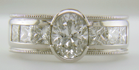 Custom platinum ring with oval diamond and 6 Princess cuts.
