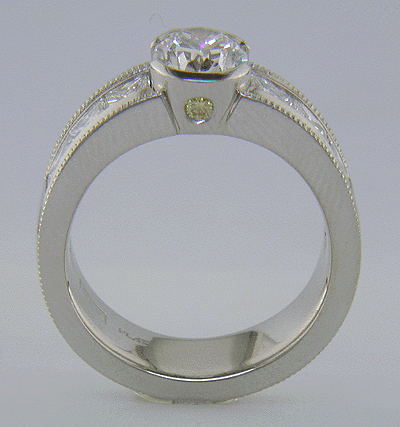 Side view of custom platinum ring with oval diamond and 6 Princess cuts.