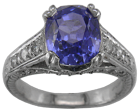 Estate sapphire with diamond ring crafted in engraved platinum.