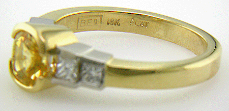 Fancy yellow sapphire ring with princess cut diamonds.