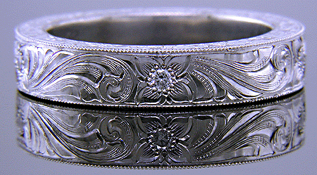 Hand engraved platinum band set with diamonds.