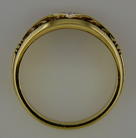 Profile view of 18kt gold band with engraved details and a diamond.