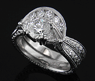 Hand engraved platinum engagement ring with diamonds and matching wedding band.
