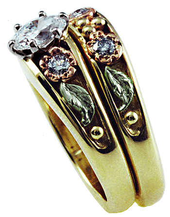 Side view of custom wedding rings crafted in yellow, rose and green gold.