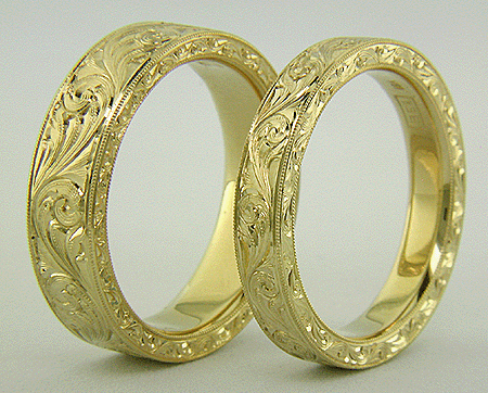 Hand-engraved 18kt gold bands with flowing scrolls.