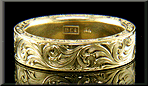 Hand-engraved 18kt gold band with flowing scrolls.