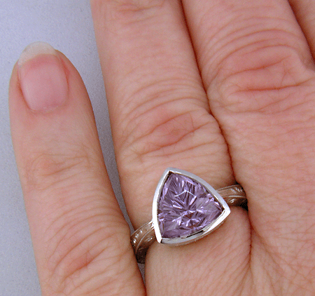 Concave-faceted Amethyst set in an engraved platinum ring. (J7415)