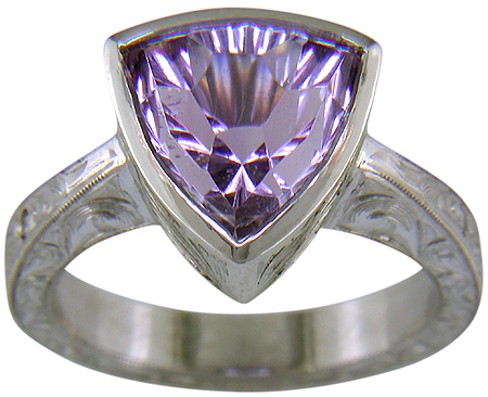 Concave-faceted Amethyst set in an engraved platinum ring. (J7415)