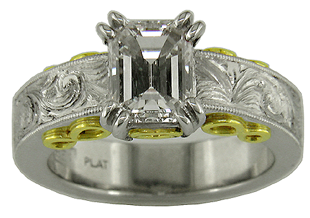 Hand-engraved platinum engagement ring with an emerald cut diamond.
