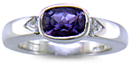 Violet sapphire with trilliant diamonds in a custom platinum ring.