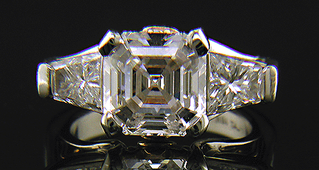 An Asscher-cut diamond set with two trapezoid-cut diamonds in a custom platinum ring