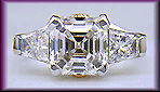 An Asscher-cut diamond set with two trapezoid-cut diamonds in a custom platinum ring.