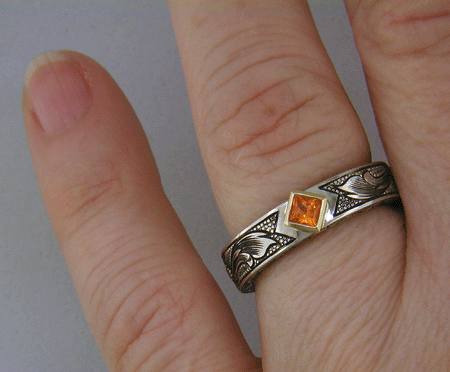 A beautifully hand-engraved ring set with fiery orange Manderin Garnets. (J8703)