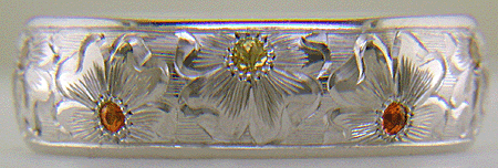 Hand engraved platinum band set with mandarin garnets.