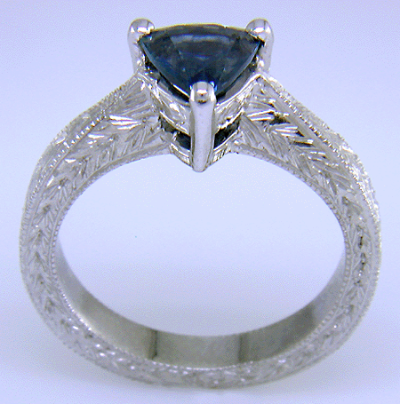 Side view of platinum engraved ring with trillium Montana sapphire.