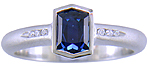 Morph-cut Sapphire with round diamonds in a custom platinum ring.