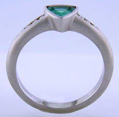 Side view of Paraiba tourmaline accented with diamonds in a custom platinum ring.