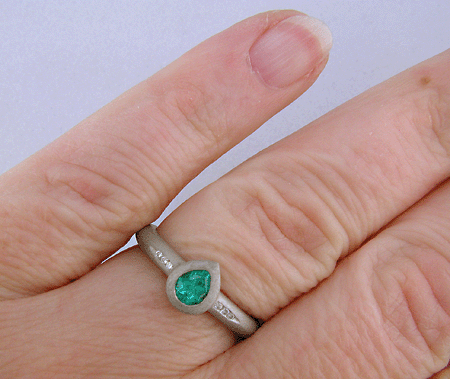 Hand view of pear-shape Paraiba tourmaline accented with diamonds in a custom platinum ring.