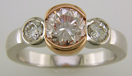 A brilliant fancy light pink diamond set in an 18kt rose and white gold ring.