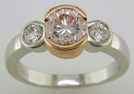 A brilliant fancy light pink diamond and colorless diamonds set in an 18kt rose and white gold ring.