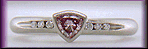 Trilliant pink diamond set with round brilliant-cut diamonds in a custom platinum ring.